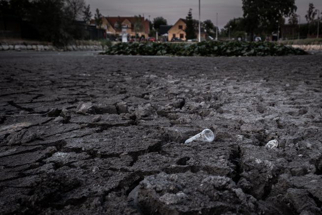 Udtørret gadekær med tom flaske