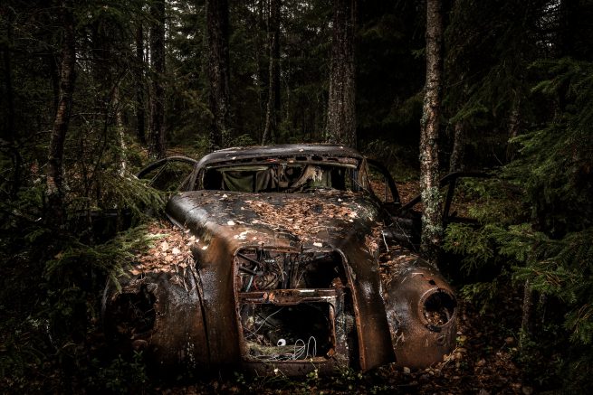 Gammel rusten bil på bilkirkegård